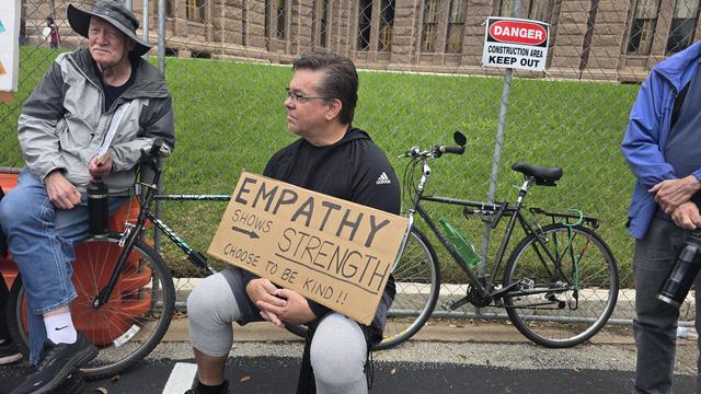 A guy with a sign: Empathy Shows Strength, Choose to Be Kind