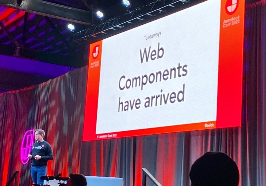 Laurie Voss on stage and the slide reads “Web Components have arrived”
