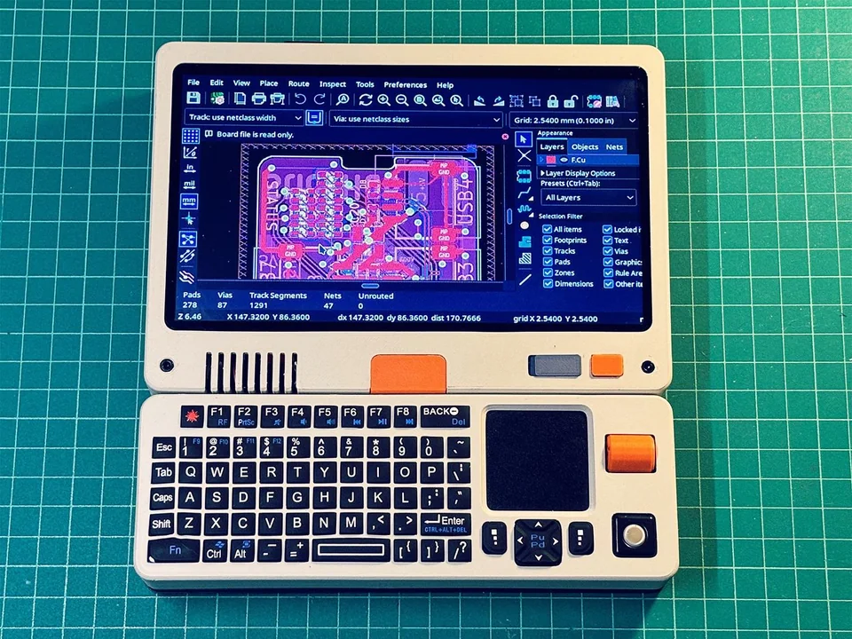 The piet, a cool retro-futuristic handheld console, showing KiCAD on screen.