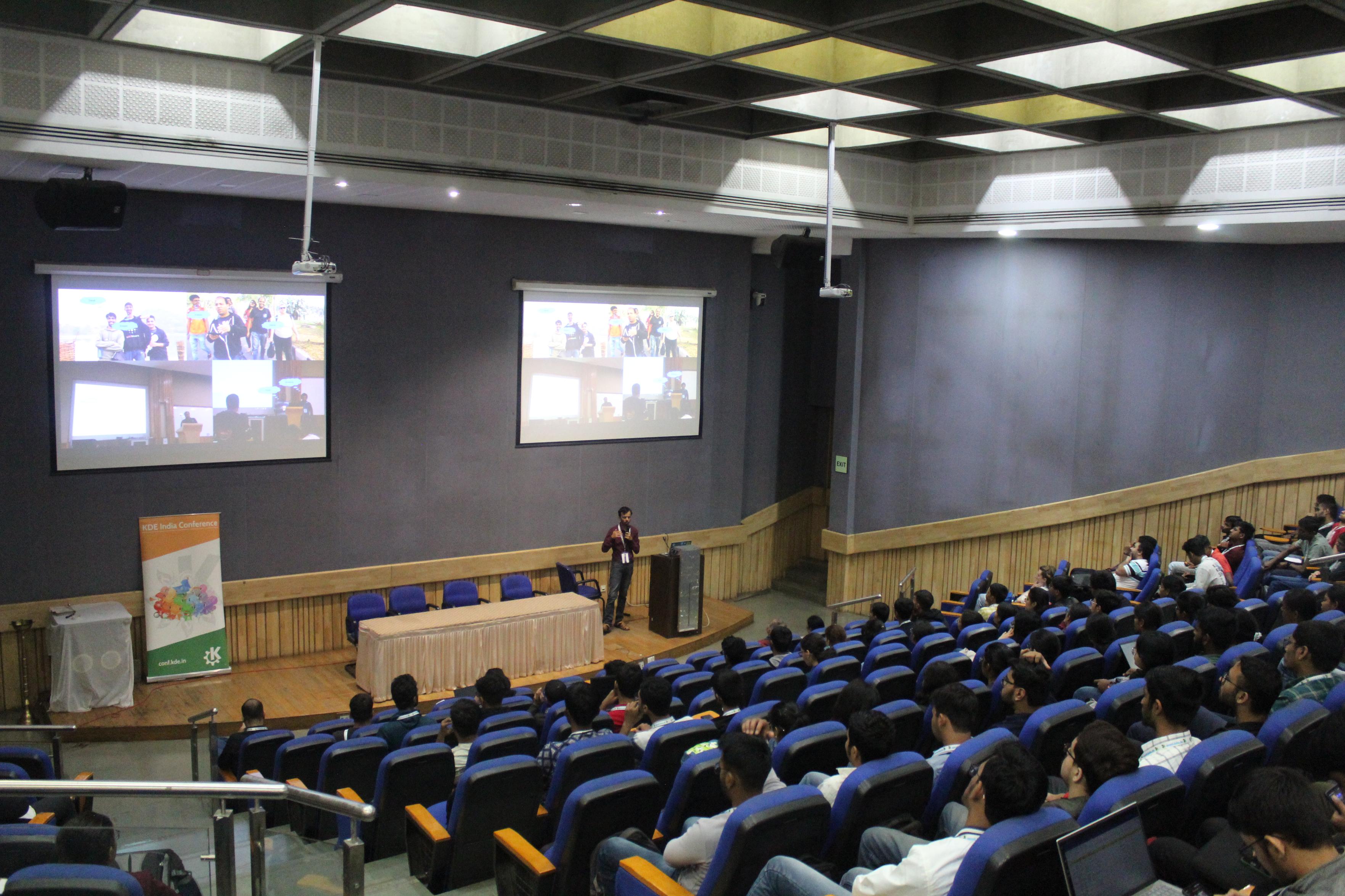 Picture from conf.kde.in 2024. A hall with a speaker and attendees.