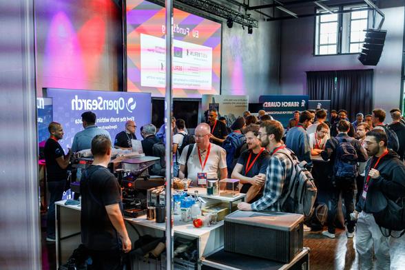 Attendees chatting with the partner teams at their booths