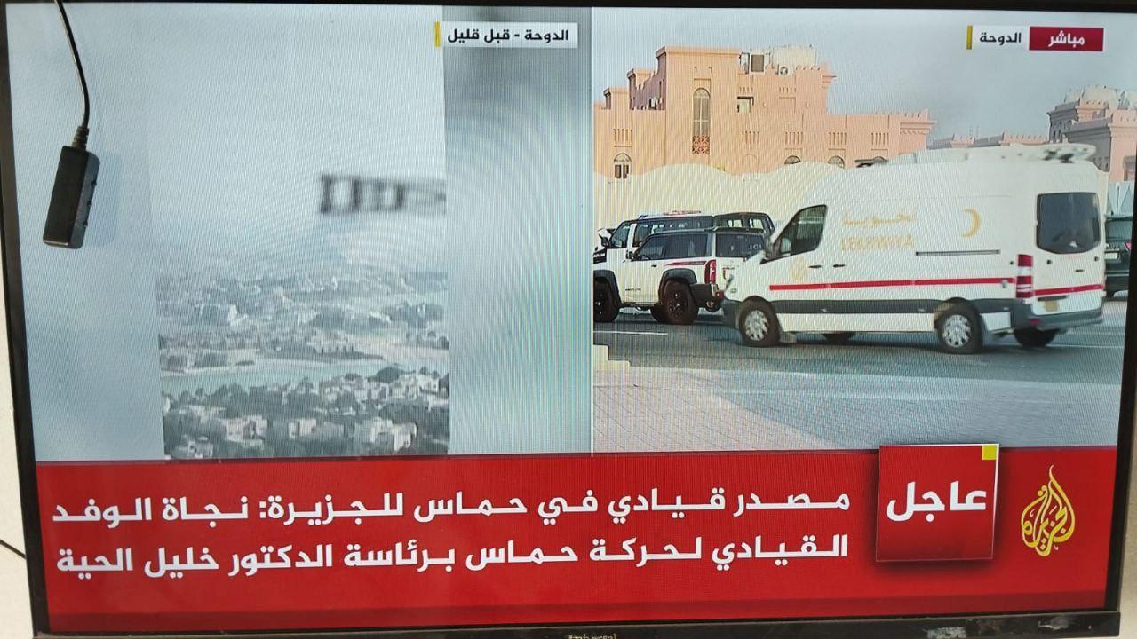 Photo of Al Jazeera TV with images of bombing site in Doha and some ambulances
