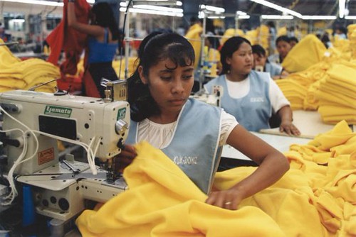 Photo of multiple women working in a textile sweat shop