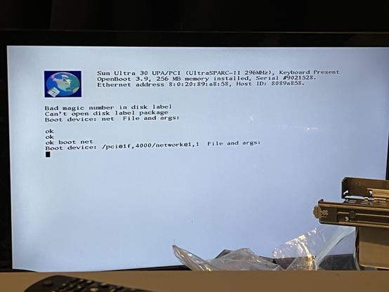 A computer screen displaying an error message from a Sun Ultra 30 system, indicating issues with the disk label and boot device configuration. The screen shows a blue globe logo and a series of error messages about a "bad magic number in disk label" and a line that shows it’s trying to boot using the network port