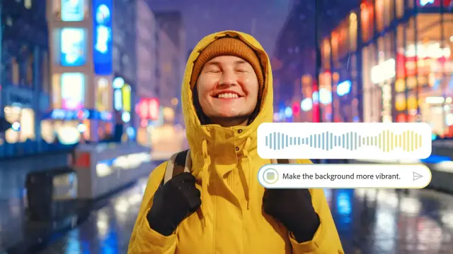 A smiling person in a yellow jacket stands in a vibrant city at night, with neon lights reflecting off wet streets and a voice command prompt visible.