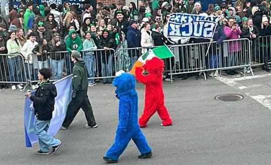 Muppets and a guy with a YANKEES SUCK flag at St. Patrick's parade in South Boston