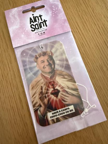 Saint Bob Mortimer air freshener with “Have a campa choo-choo on me"
