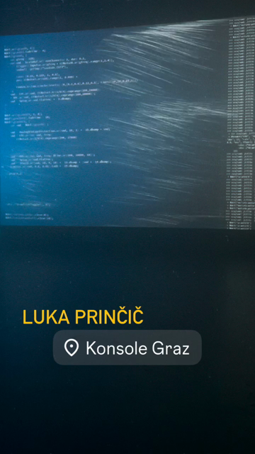 a hazed room with big projection of code  and a person standing in dark behind equipment