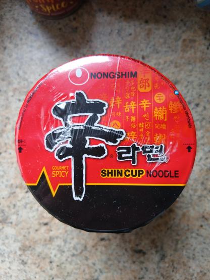 Top of a noodle cup. The brand is Shin Cup Noodle.

It also says Gourmet Spicy and I think it was beef flavour.