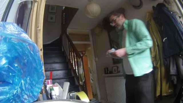 Screenshot from our hallway camera. It shows me (a middle aged man) in a green shirt and black linen trousers.