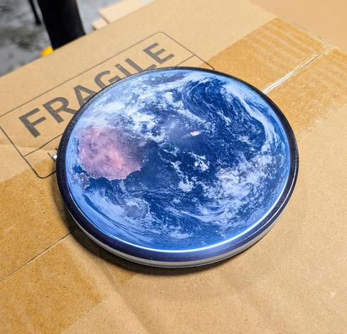 A circular ceramic coaster with a picture of the Earth on it.