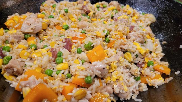 A close up of egg fried rice sitting in a wok