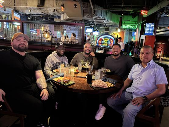 4 Str8s and 1 homo sitting at a dinner table in a restaurant, smiling.