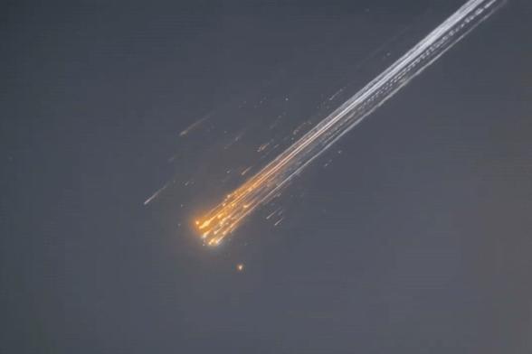 A cluster of debris burns in the Earth's atmosphere like a flotilla of meteors in tight formation.