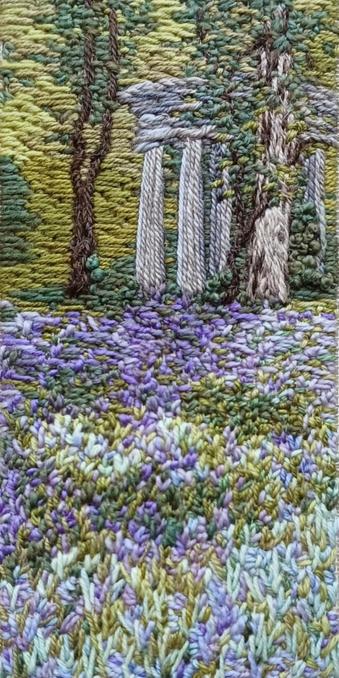Stitched artwork depicting a woodland scene with a sea of bluebells in the foreground and a pillared folly in the background.