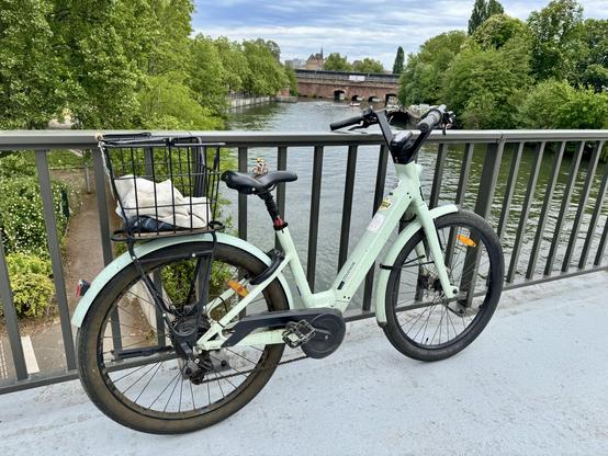 Une vélo (avec un lego sur la selle) sur un pont. Derrière on voit l’île et les ponts couverts.