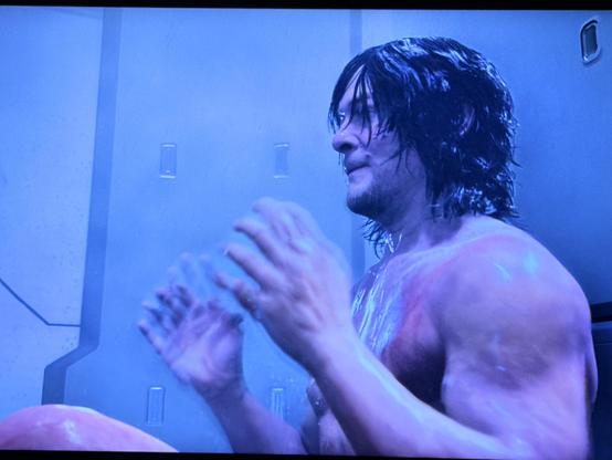 A screenshot of the video game Death Stranding 2 showing Sam in the shower