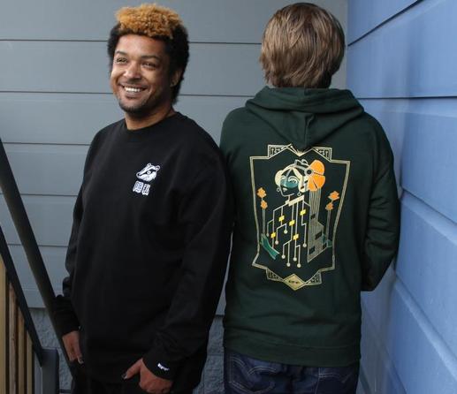 Two people wearing EFF apparel. One wearing EFF's Privacy Badger crewneck and one wearing EFF's Motherboard Hoodie