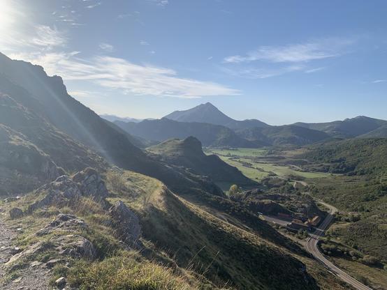 Mountains, lush green valleys, and more mountains in the distance under a clear blue sky.