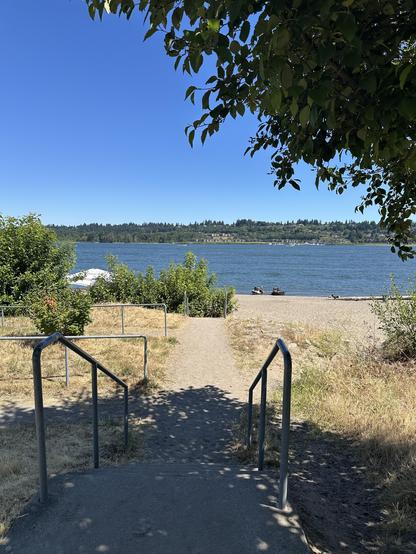 A sandy path down to the broad Columbia River on a warm, sunny day.