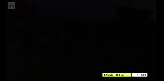 A darkness of the night with pretty much nothing visible but an on-screen graphic about first leg finish and time 1:18:39.