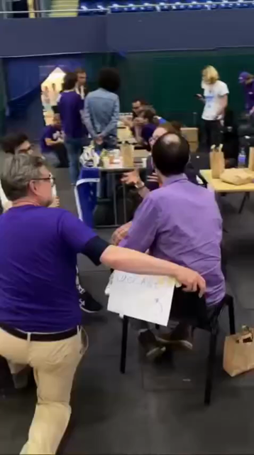 Me sitting at a chair surround by people in purple VOLT tshirts gesticulating and speaking "heavily".
