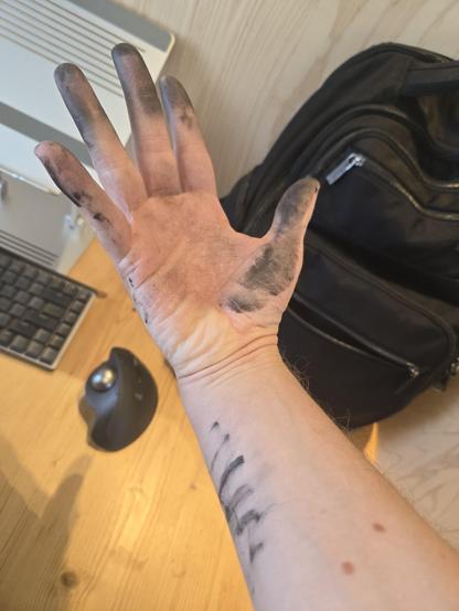 Photo of my hand covered in black bike chain dirt