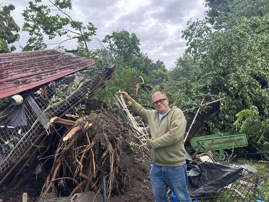 ken standing in front of an uprooted black walnut tree. The roots pushed the floor of a dog kennel about 6 feet away from the ground.