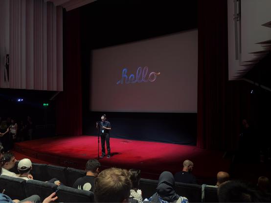A theatre with Apple’s “hello” logotype on the screen
