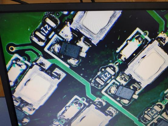 microscope view of a couple of smd diodes that are rotated about 30 degrees from where they should be, so only one pin of each is connected
