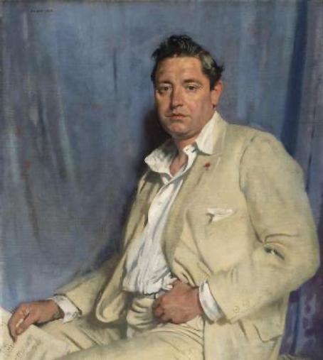 The image is a portrait of a man dressed in a light-colored suit and white shirt, sitting casually. He has short, dark hair and a fed up expression, with a blue background behind him.