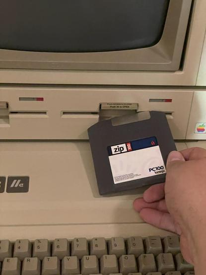 Me teasingly attempting to insert a Zip disk into an Apple II disk drive