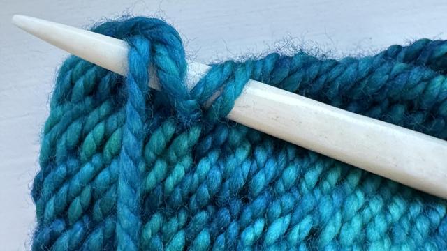 Nalbinding needle inserted through two loops of the previous row and then two loops of the new row.