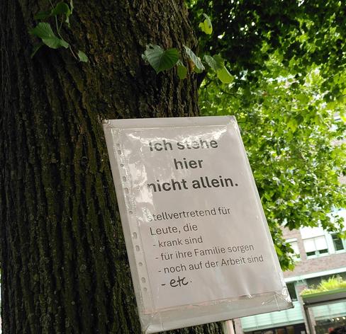 Demoschild, darauf steht "Ich stehe hier nicht allein. Stellvertretend für Leute, die krank sind, für ihre Familie sorgen, noch auf der Arbeit sind et cetera"