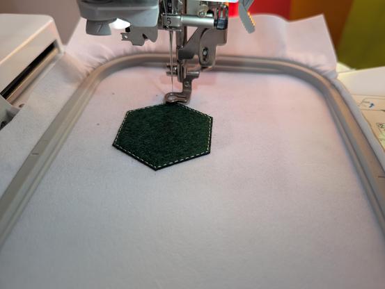 picture of patch being embroidered with embroidery machine, showing patch with tacking stitch
