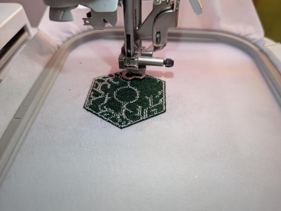 picture of patch being embroidered with embroidery machine, showing half-complete patch