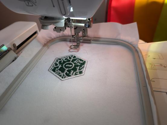 picture of patch being embroidered with embroidery machine, showing complete patch, with loose strands not tidied up