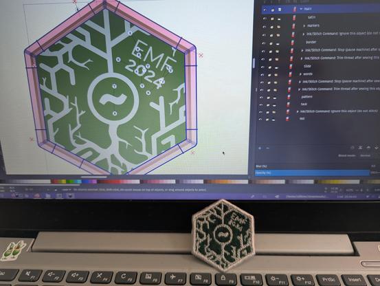 picture of emf camp embroidered patch next to laptop showing design file