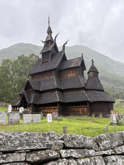 800 year-old Norwegian stave church with shingled roof and ornate wood carvings.