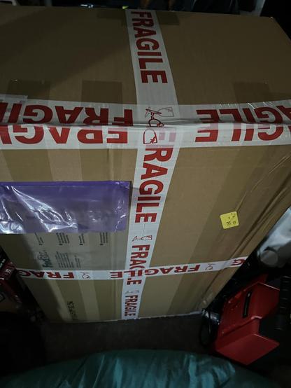 A large brown box with fragile tape