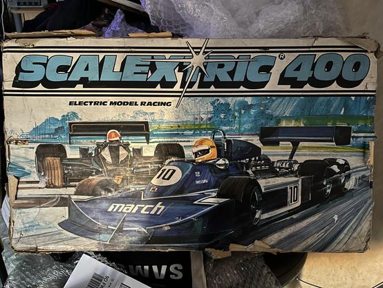 A vintage Scalextric 400 electric model racing box featuring artwork of two racing cars, highlighting a blue car with the number 10 and a black car with the number 5. The box shows signs of wear, with a colorful background