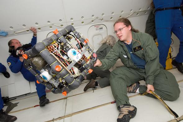 Yours truly moving an experimental free-flying robot into position during a parabola on the NASA "Weightless Wonder" (AKA Vomit Comet) almost exactly 20 years ago. Everyone is bracing themselves to keep from drifting around uncontrolled. NASA employees are in blue jumpsuits, students in green.