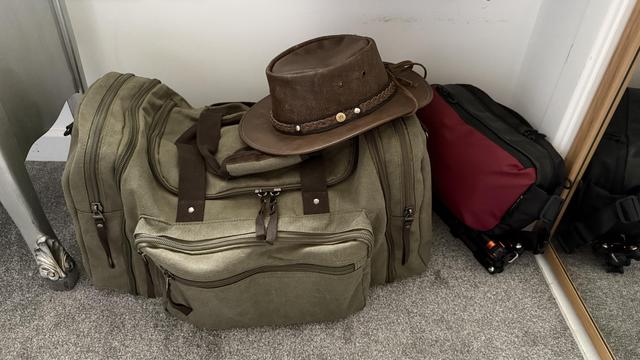Hat on duffel bag, with camera bag alongside