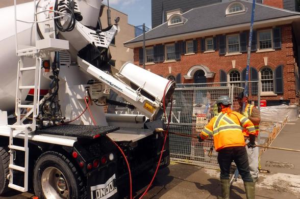 shiny new concrete mixer being hosed down and brushed off in front of 1067 Yonge... the fresh concrete has already been flattened and smoothed out in the new driveway at right