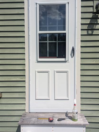 White storm door with raised trim attached. 
Trim had been broken since the steps were repaired a few years ago.