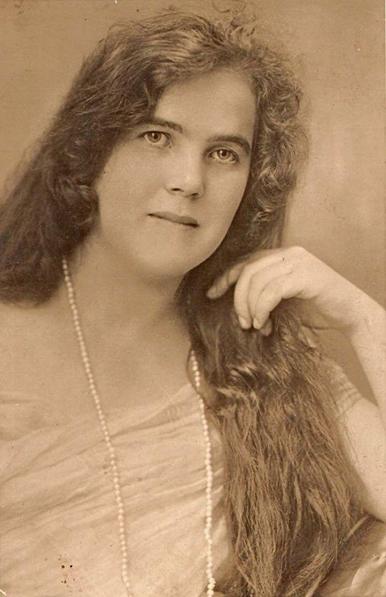 Vintage sepia-toned portrait of a woman with long, flowing hair, wearing a necklace