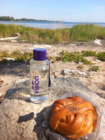 En megastor kardemummaknut, min vattenflaska från Vision på en stenkoll med utsikt över havet