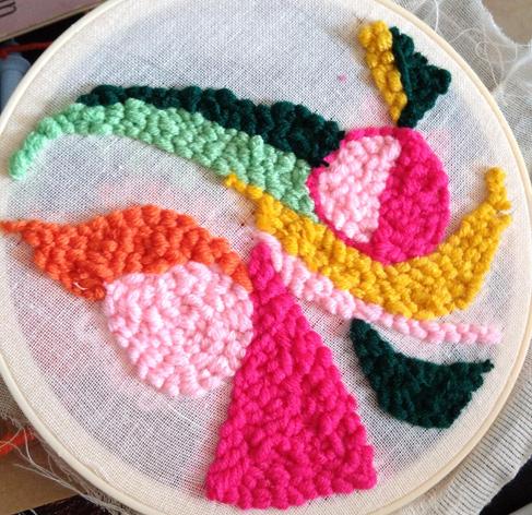 An abstract doodle in colourful yarn using a punch needle