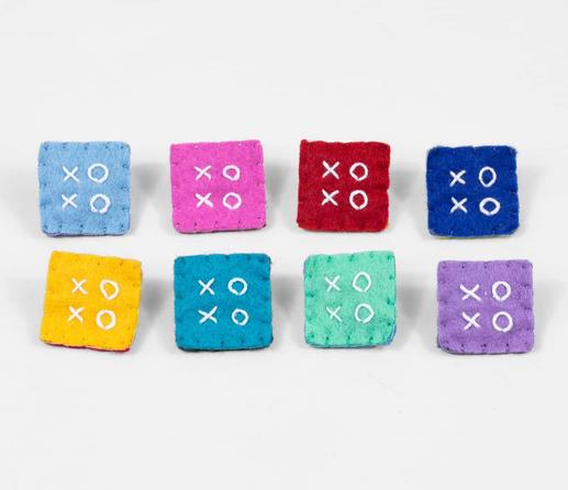 Photo of 8 square felt pins, each in a different color, each with the letters “XOXO” in the center