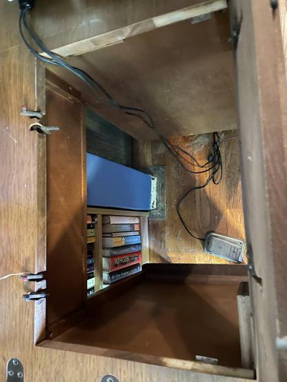 The space in the table for the machine. There are two pairs of little metal prongs that swivel up and down. On the other side, there is a shelf that swivels up and down.